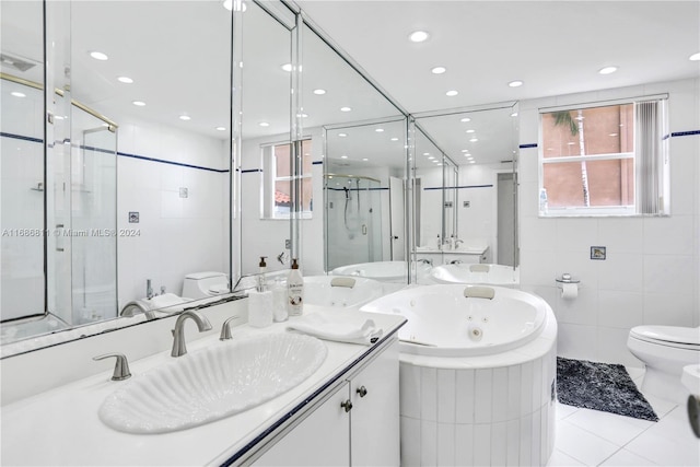 full bathroom featuring independent shower and bath, vanity, tile patterned floors, toilet, and tile walls