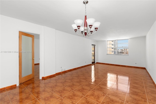 tiled empty room with an inviting chandelier