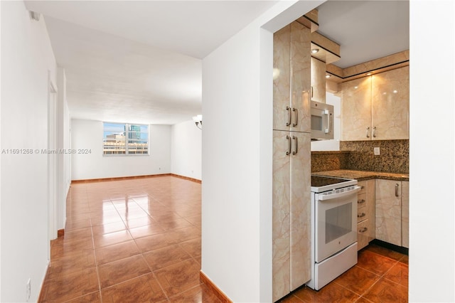 kitchen featuring tasteful backsplash, tile patterned floors, and white appliances