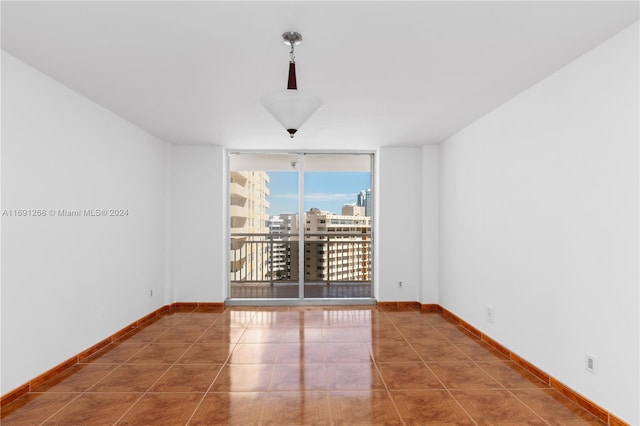 tiled empty room featuring floor to ceiling windows