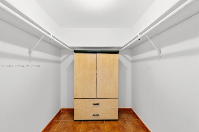 walk in closet with dark tile patterned flooring