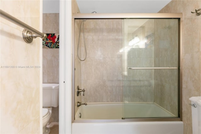 bathroom featuring shower / bath combination with glass door and toilet