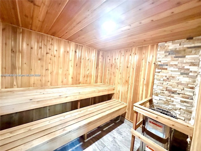 view of sauna / steam room with wood-type flooring, wooden walls, and wood ceiling