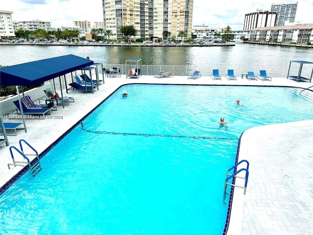 view of swimming pool with a patio and a water view