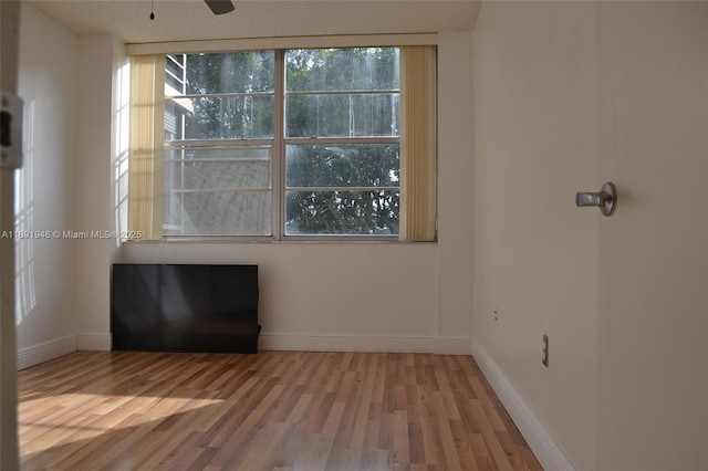 unfurnished room with ceiling fan and hardwood / wood-style flooring