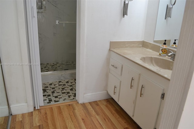 bathroom with vanity, hardwood / wood-style flooring, and walk in shower