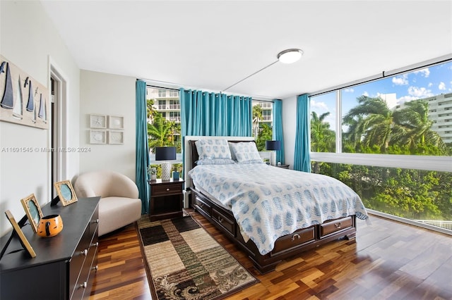 bedroom featuring expansive windows and dark hardwood / wood-style floors