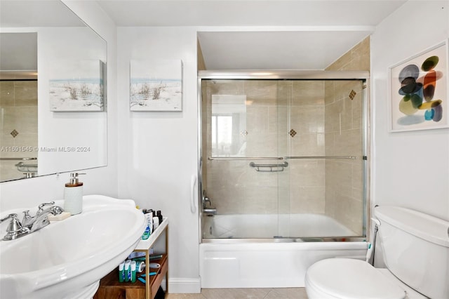 full bathroom featuring toilet, sink, and enclosed tub / shower combo