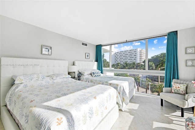 bedroom with multiple windows, light tile patterned floors, and floor to ceiling windows