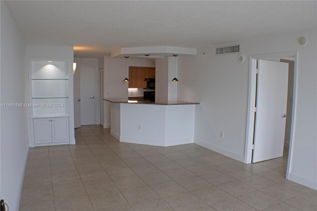 interior space featuring a textured ceiling and light tile patterned flooring