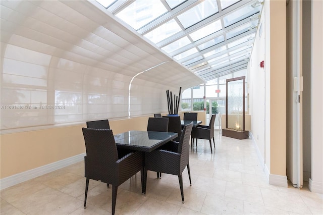 dining area with light tile patterned floors and a skylight