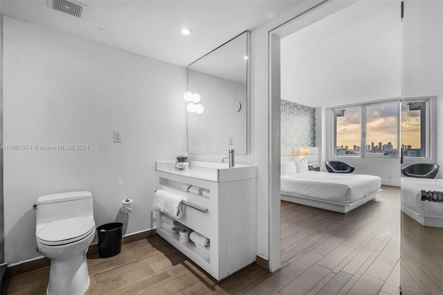 bathroom featuring hardwood / wood-style floors, vanity, and toilet