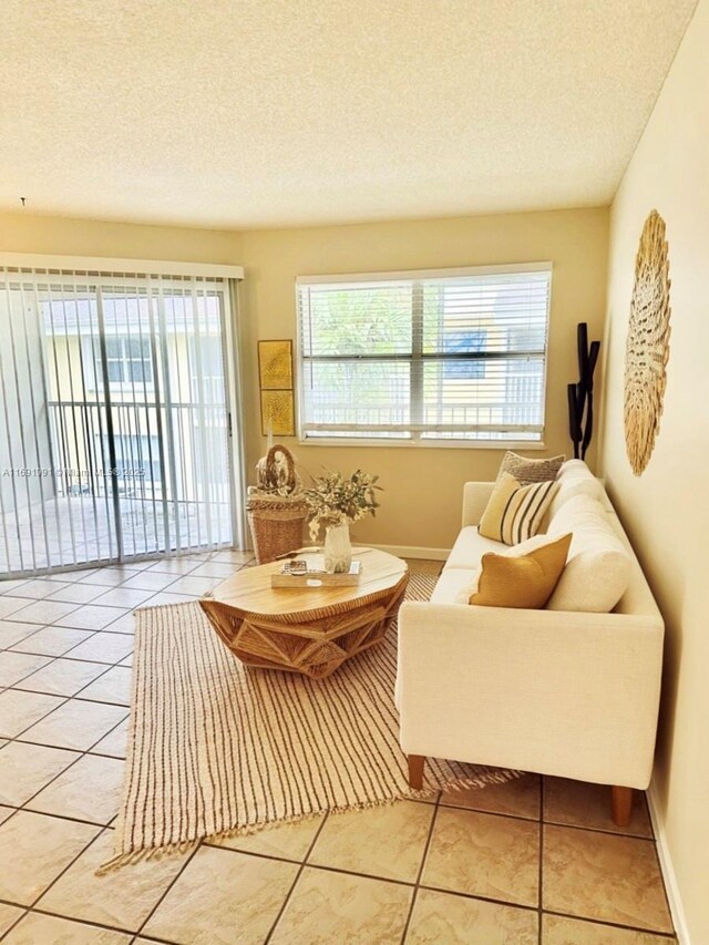 living area with tile patterned flooring and a textured ceiling