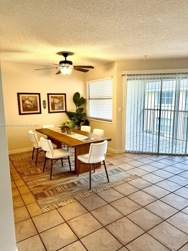 dining space with ceiling fan, tile patterned floors, and a textured ceiling