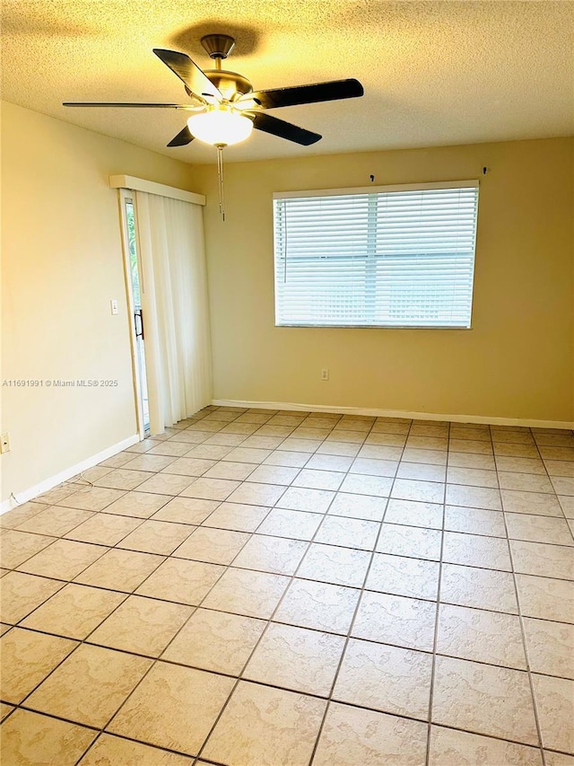 tiled spare room featuring ceiling fan and a textured ceiling