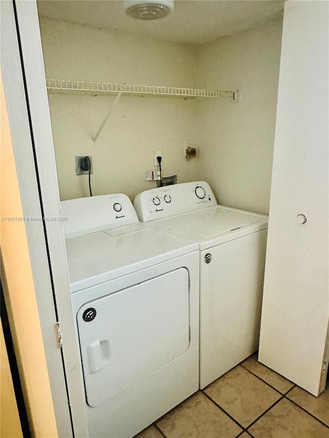 washroom with washer and dryer and light tile patterned floors