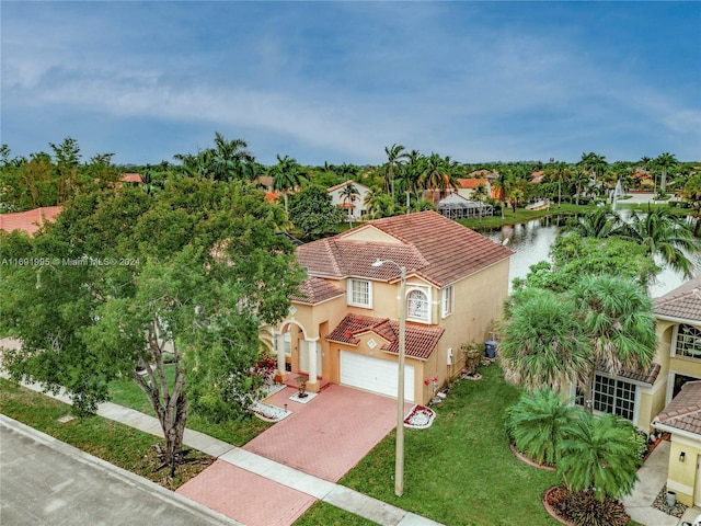 view of front of property with a garage, central AC unit, a water view, and a front lawn