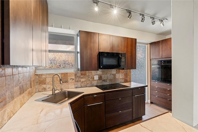 kitchen with black appliances, tasteful backsplash, dark brown cabinets, sink, and rail lighting