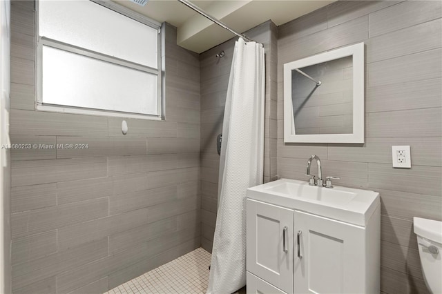 bathroom with tile walls, vanity, curtained shower, and toilet