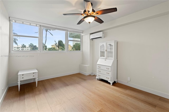 unfurnished bedroom with ceiling fan, light wood-type flooring, and a wall mounted air conditioner