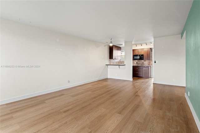 unfurnished living room with ceiling fan and light wood-type flooring