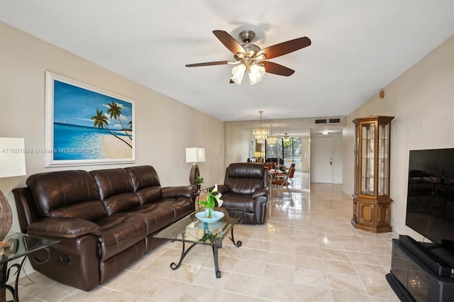 tiled living room featuring ceiling fan with notable chandelier and a textured ceiling