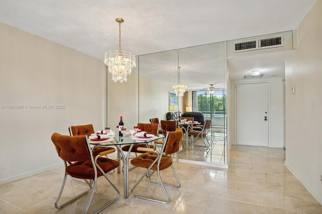 dining space with ceiling fan with notable chandelier and a textured ceiling