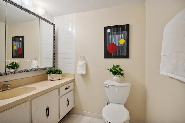 bathroom featuring toilet, vanity, and tile patterned flooring