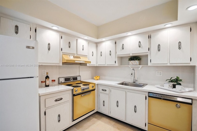 kitchen with white fridge, dishwashing machine, stove, white cabinets, and sink