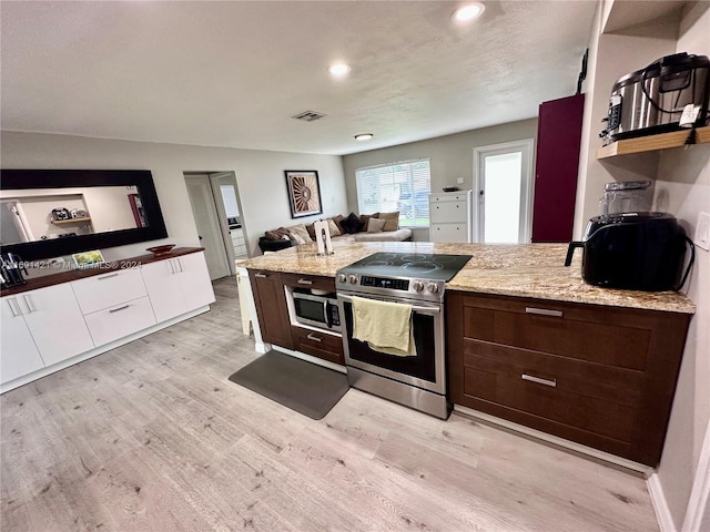 kitchen with dark brown cabinetry, light wood-type flooring, appliances with stainless steel finishes, and light stone counters