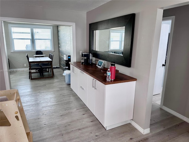 kitchen with white cabinets, plenty of natural light, and light hardwood / wood-style floors