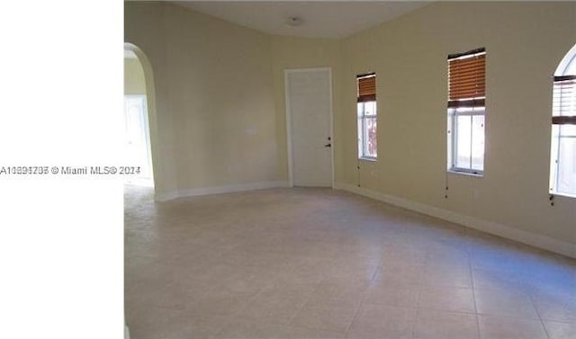 tiled spare room with a wealth of natural light