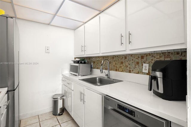 kitchen featuring stainless steel appliances, white cabinets, sink, and backsplash