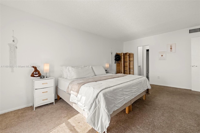 bedroom featuring carpet and a textured ceiling