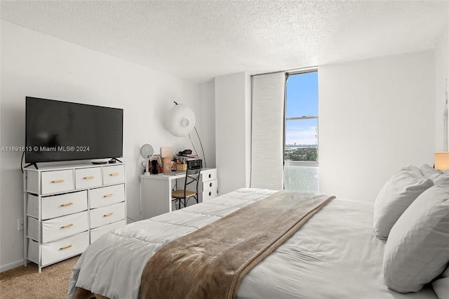 bedroom featuring a textured ceiling and light carpet