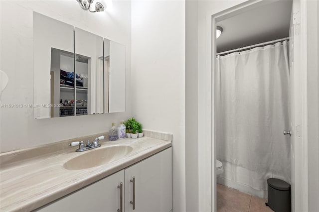 bathroom with walk in shower, vanity, toilet, and tile patterned flooring