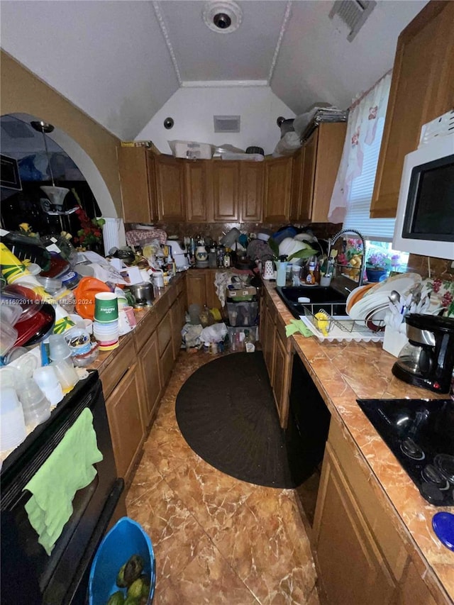 kitchen featuring sink, vaulted ceiling, and black electric cooktop