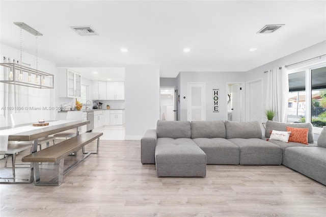 living room featuring sink and light wood-type flooring