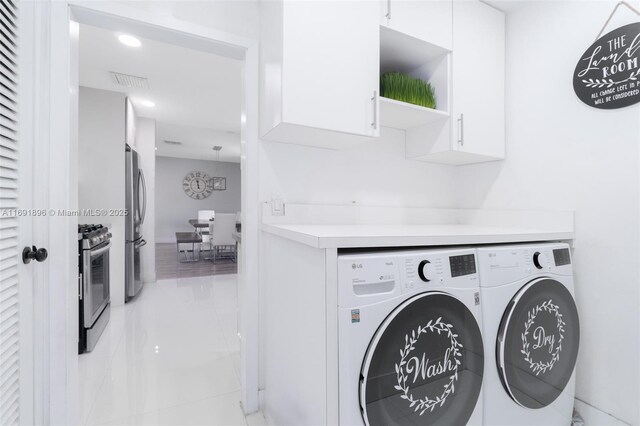 laundry room with cabinets and washer and clothes dryer