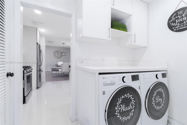 laundry room featuring cabinets and washing machine and clothes dryer