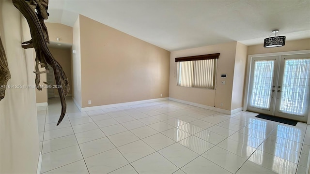 entrance foyer with french doors, light tile patterned floors, and lofted ceiling