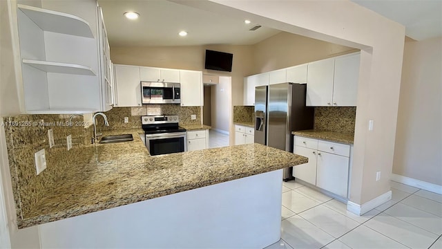 kitchen with kitchen peninsula, stainless steel appliances, lofted ceiling, and sink