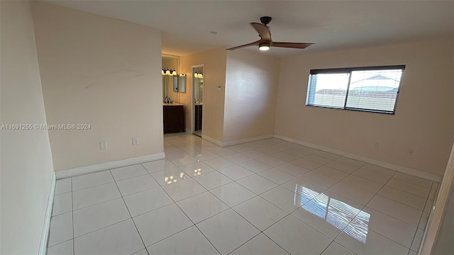 tiled spare room with ceiling fan