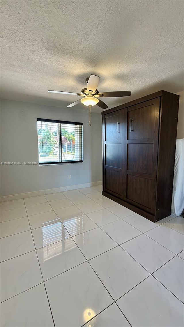 unfurnished bedroom with ceiling fan, a closet, and a textured ceiling