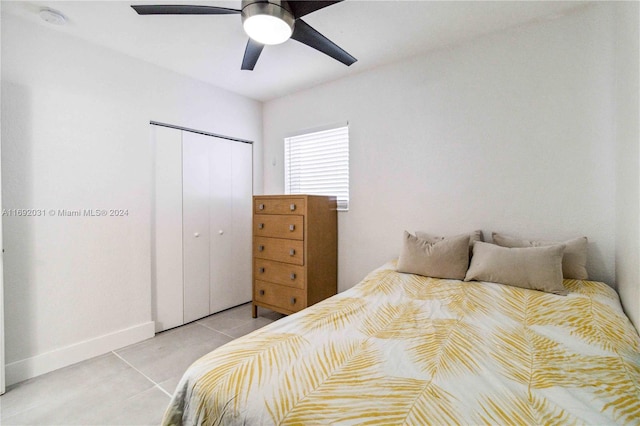 bedroom with ceiling fan, a closet, and light tile patterned floors