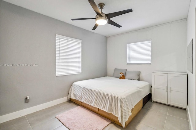 tiled bedroom with ceiling fan and multiple windows