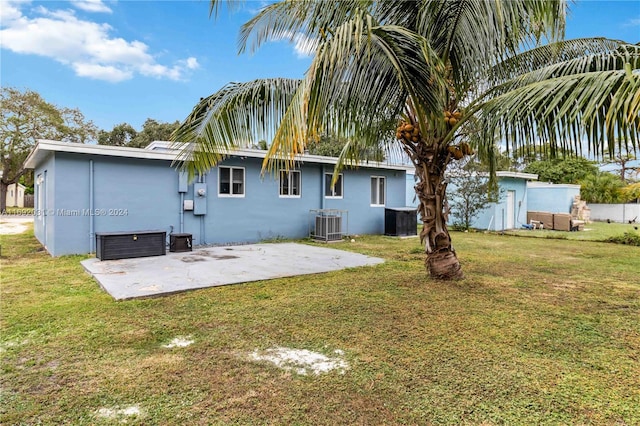 back of house with a patio area, a yard, and central AC