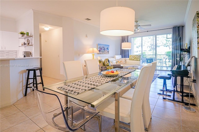 tiled dining room featuring ceiling fan and ornamental molding