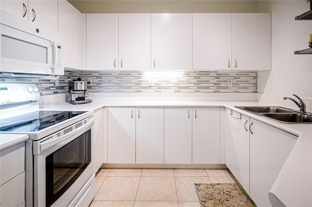 kitchen featuring range, sink, decorative backsplash, light tile patterned floors, and white cabinetry