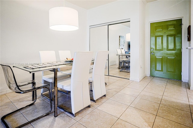 dining space with crown molding and light tile patterned floors